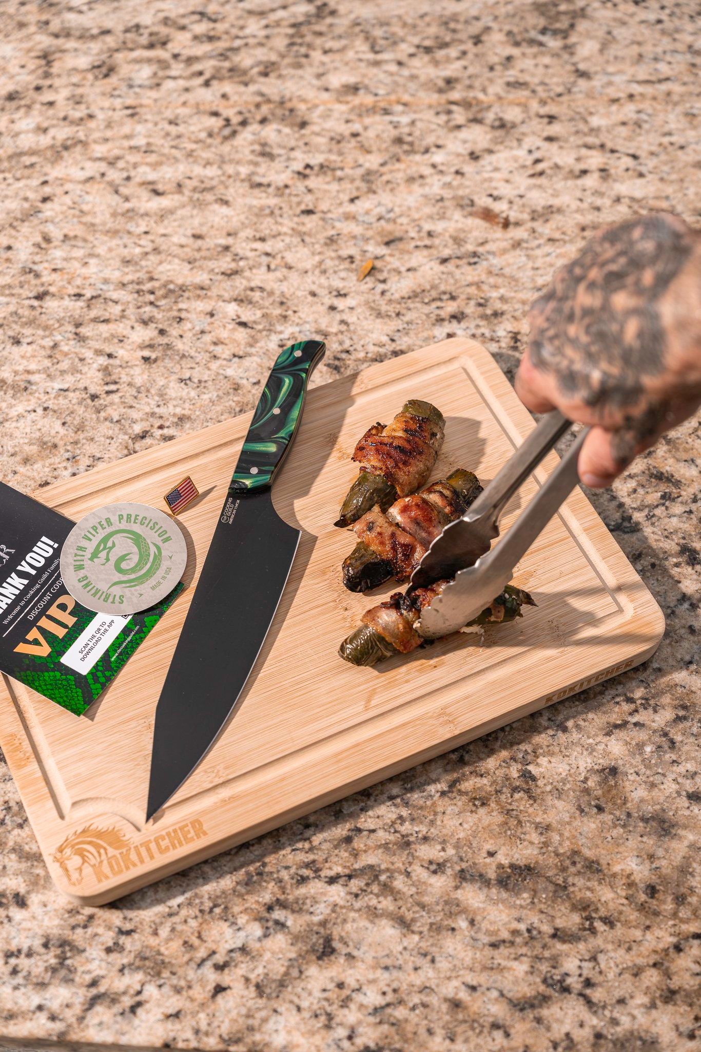 The Cooking Guild knife on a cutting board with grilled food