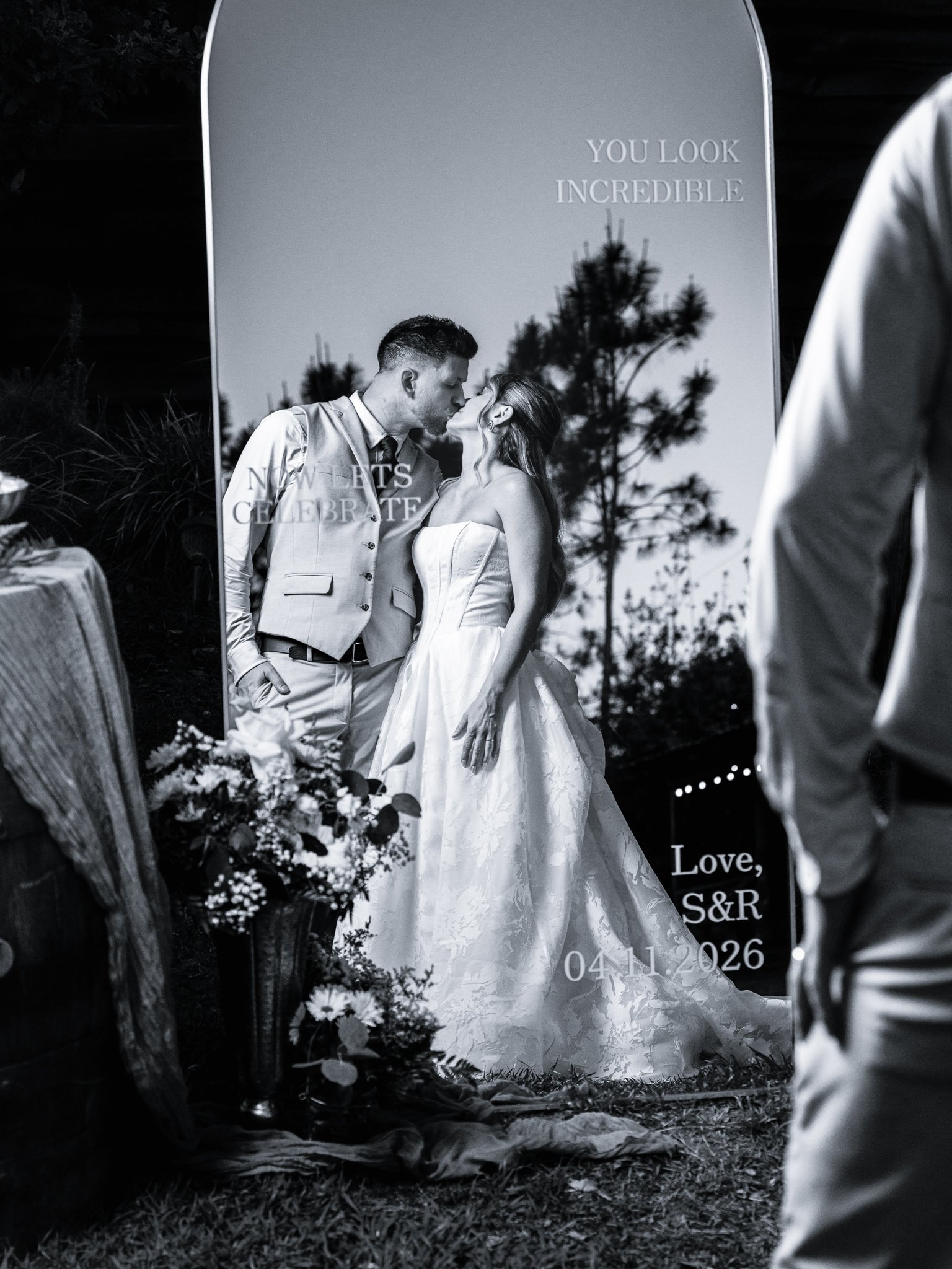 Black and white wedding portrait beside a welcome mirror